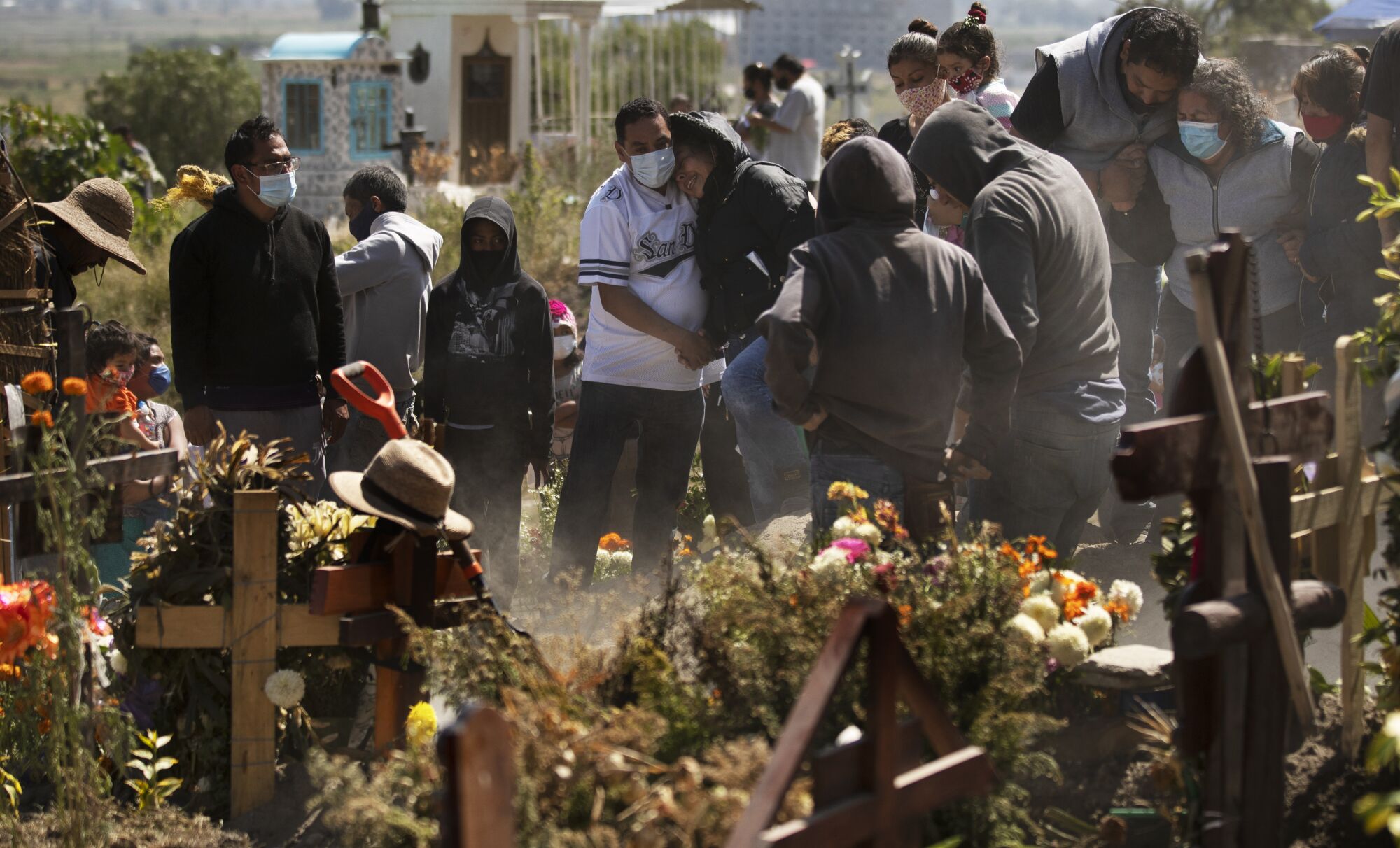 A group of people stand around a gravesite