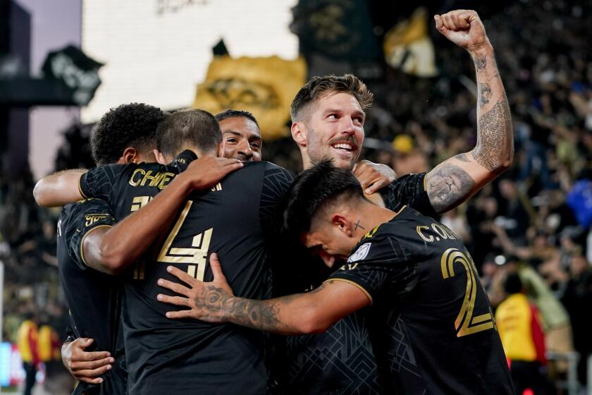 Los Angeles FC midfielder Ryan Hollingshead, top right, is surrounded by teammates.