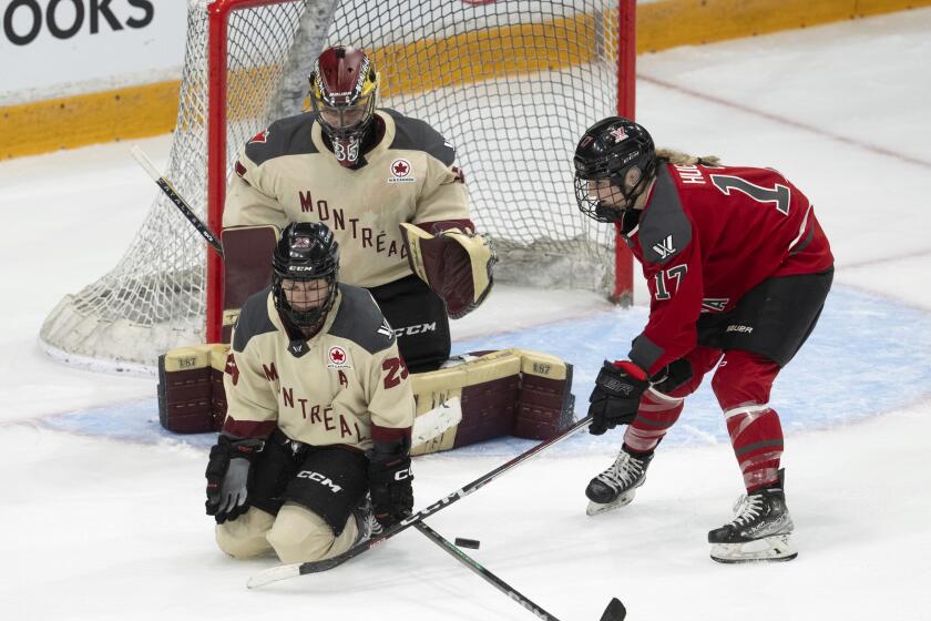Montreal goalie Ann-Renee Desbiens looks on as defender Erin Ambrose blocks a shot while Ottawa forward Gabbie Hughes tries to get her stick on the puck during the third period of a PWHL hockey game, Saturday, April 27, 2024 in Ottawa, Ontario. (Adrian Wyld/The Canadian Press via AP)