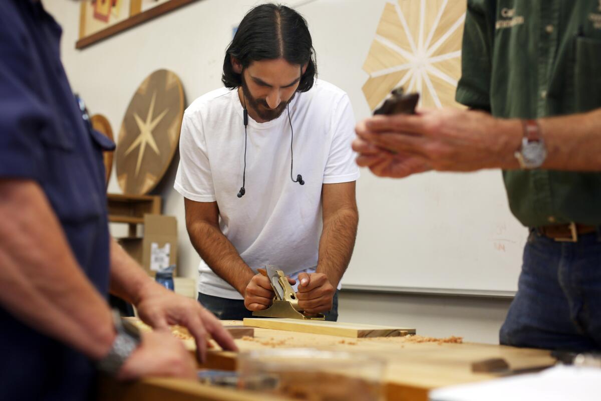 Jonny Sakhai tests a metal cutting tool during a woodworking class at Cerritos College.