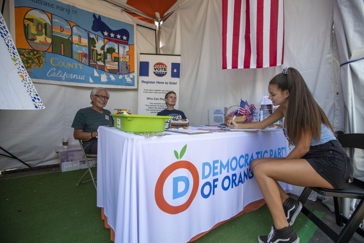 Democratic volunteers at the Orange County Fair help a woman register