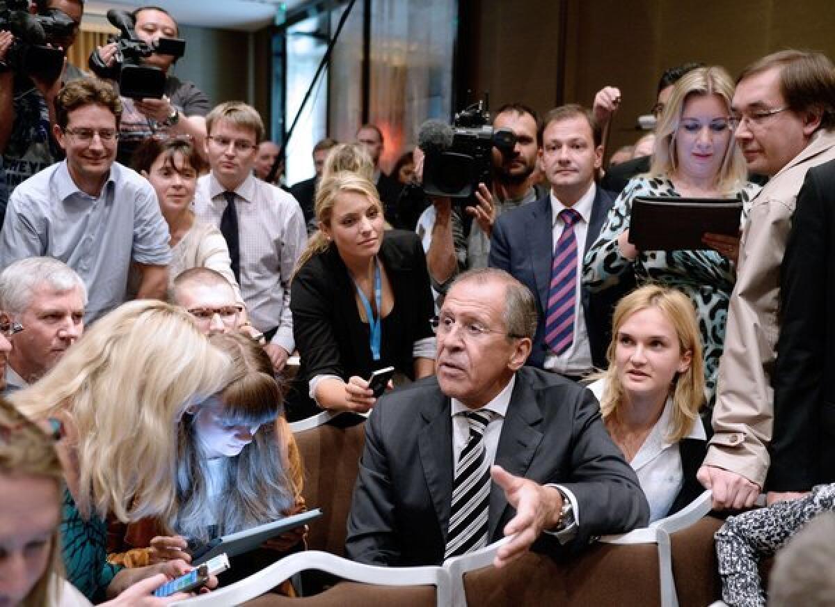 Russian Foreign Minister Sergey Lavrov, center, meets with journalists Saturday before briefing the press with his U.S. counterpart about the agreement they had reached on Syria's chemical weapons, which British and French officials have praised.