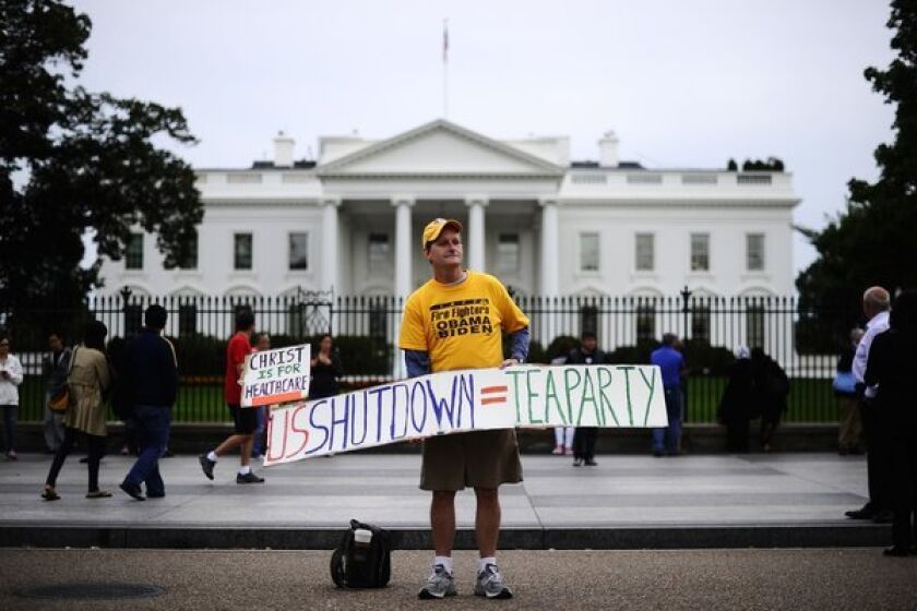A supporter of President Obama holds a placard blaming the tea party for the government shutdown Tuesday in front of the White House.