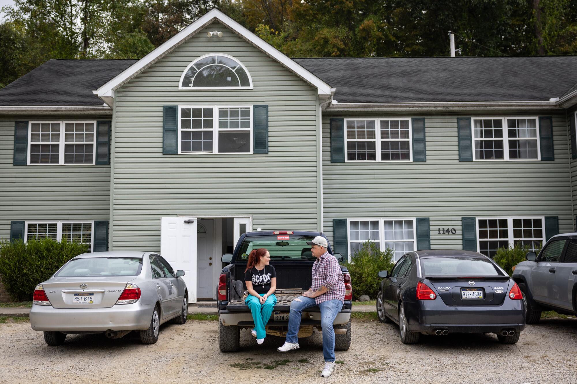 Michael, 39 and Candy Robinson talk on the tailgate of their truck outside their apartment on Monday