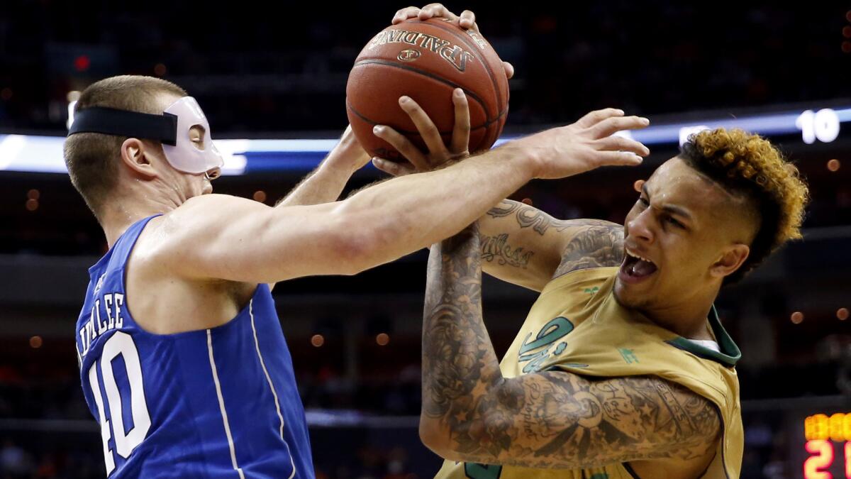 Duke center Marshall Plumlee (40) and Notre Dame forward Zach Auguste (30) battle for a rebound durin the first half of their game Thursday.