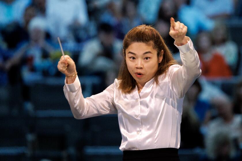 Elim Chan wields her baton conducting the L.A. Phil in her Hollywood Bowl debut on Tuesday. 