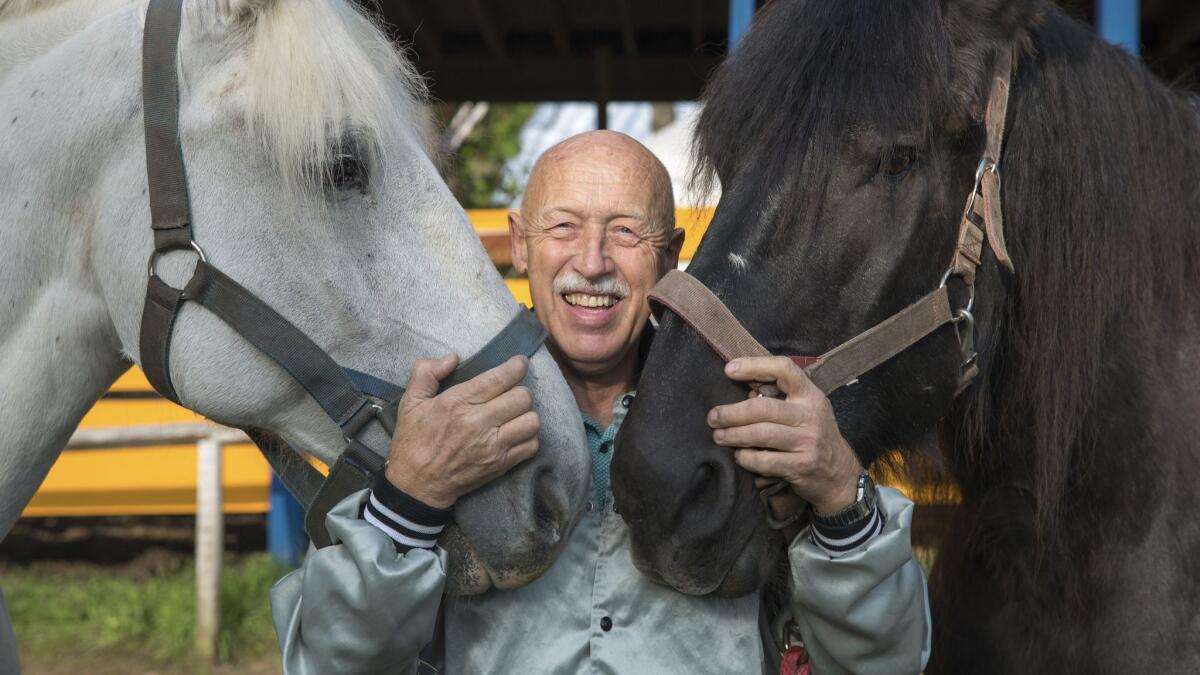 Dr. Jan Pol poses with two Percheron horses at the Michigan Renaissance Festival on on Nat Geo Wild's No. 1 series, "The Incredible Dr. Pol."