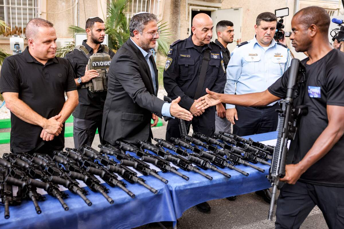 Itamar Ben-Gvir, center, distributing weapons to civilian security squads  