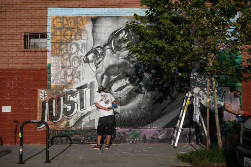 LOS ANGELES, CALIFORNIA - JUNE 23: Tristan Eaton repaints his Malcolm X mural that was defaced on Tuesday, June 23, 2020 in Los Angeles, California. (Jason Armond / Los Angeles Times)