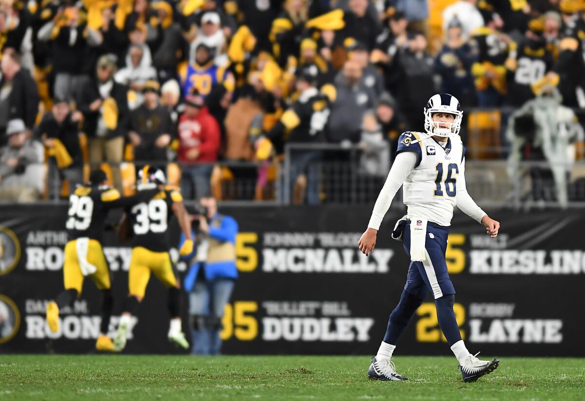 Jared Goff walks off the field after throwing an interception late.