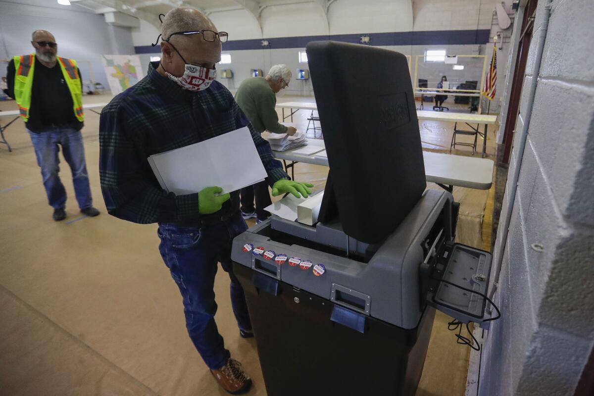 Poll worker Eric Boson submits absentee ballots during the Wisconsin 7th District special election on Tuesday in Marshfield, Wisconsin.