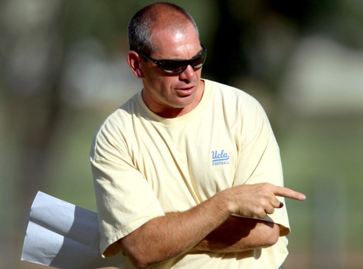UCLA defensive coordinator Lou Spanos takes the team through a drill during a summer workout.
