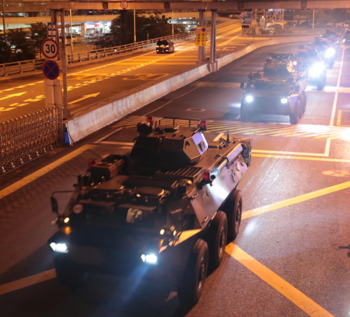 In this photo released by China's Xinhua News Agency, armored personnel carriers of China's People's Liberation Army (PLA) pass through the Huanggang Port border between China and Hong Kong, Thursday, Aug. 29, 2019. Chinese state media has published photos of the country's Hong Kong-based troops' armored carriers and a patrol boat undertaking what they call a routine rotation. (Yuan Junmin/Xinhua via AP)