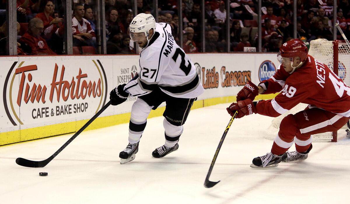 Kings defenseman Alec Martinez, bringing the puck from behind goal against Red Wings center Andrej Nestrasil last month, had surgery on an injured finger Friday.