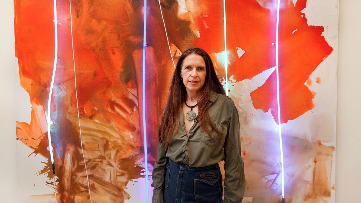 Los Angeles painter Mary Weatherford stands before her painting "Blue Cut Fire," 2017, at David Kordansky Gallery in Los Angeles.