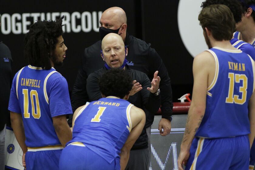 UCLA head coach Mick Cronin, center, talks to his players during the second half of an NCAA.