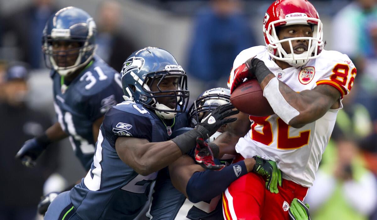 Chiefs receiver Dwayne Bowe (82) tries to break through the tackles of Seattle Seahawks cornerback Marcus Trufant (23) and safety Earl Thomas (29), during a game in Seattle.