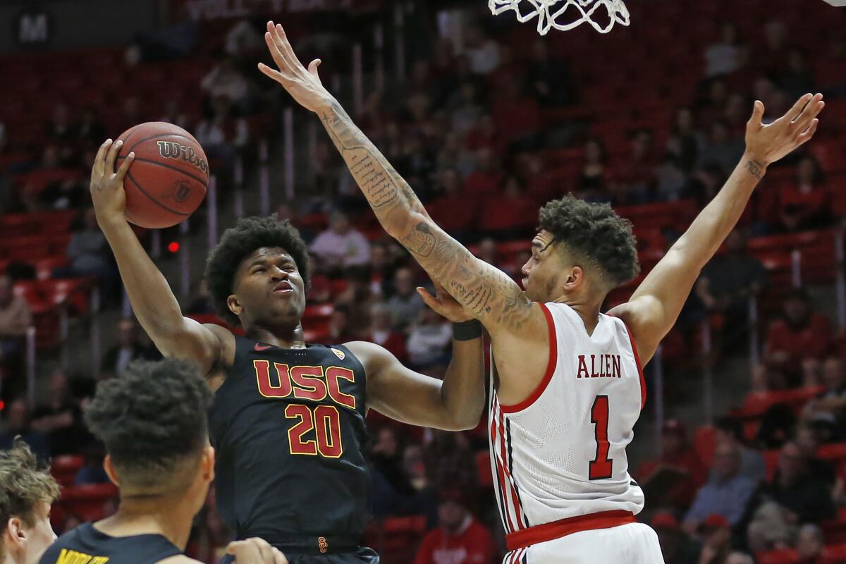 USC guard Ethan Anderson puts up a shot in front of Utah forward Timmy Allen during the first half of the Trojans' loss Sunday.