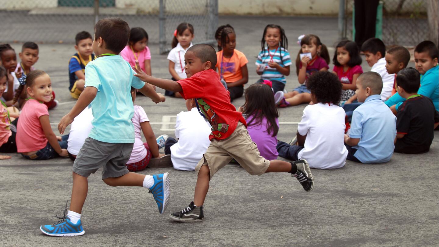 Jakobe Mara chases Tyler Rahman as they play a duck-duck-goose game during their first day of pre-kindergarten at 186th Street Elementary in Gardena on Tuesday.