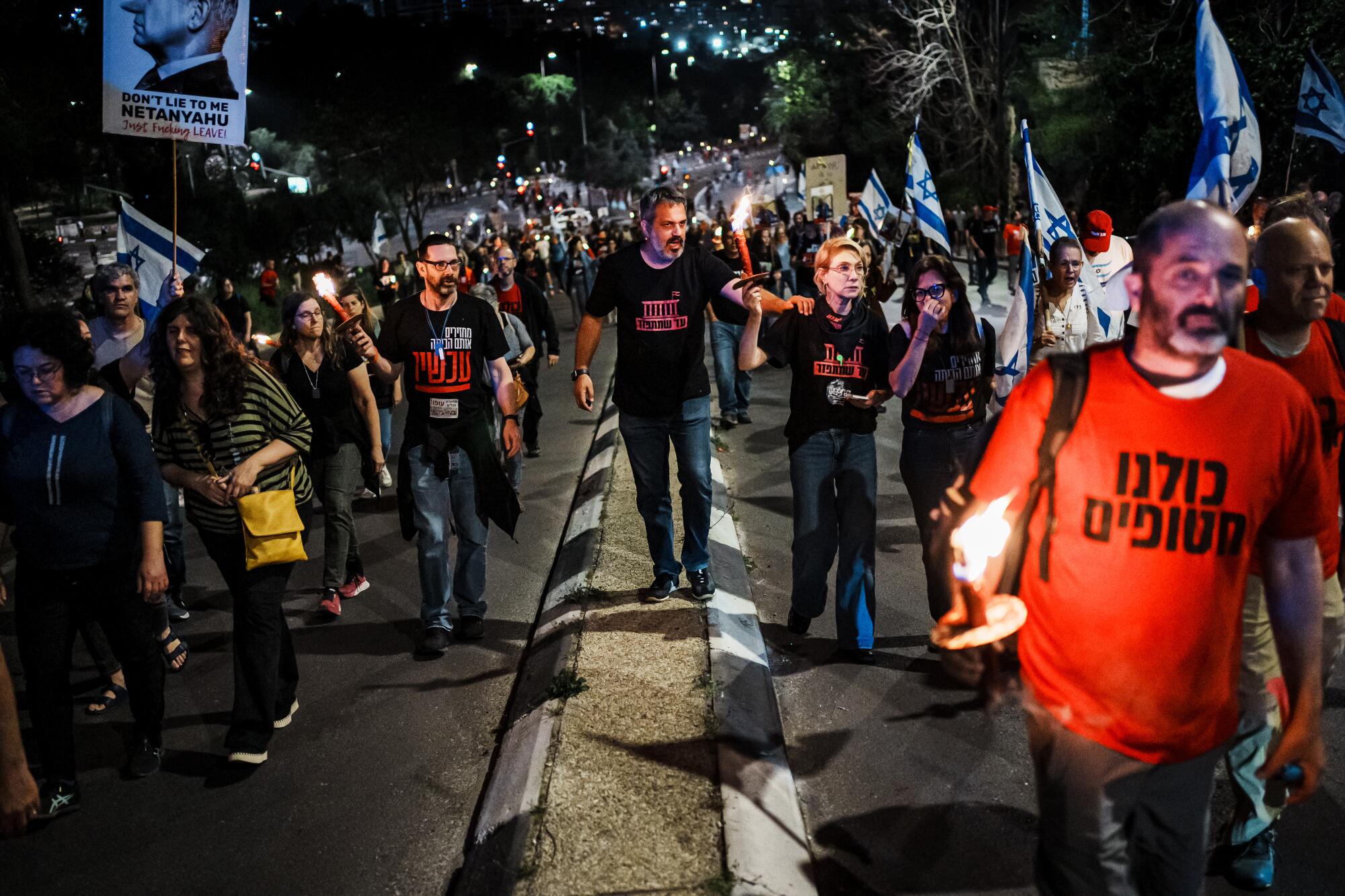 Anti-government demonstrators march up a hill towards central Jerusalem, Israel, Tuesday, 