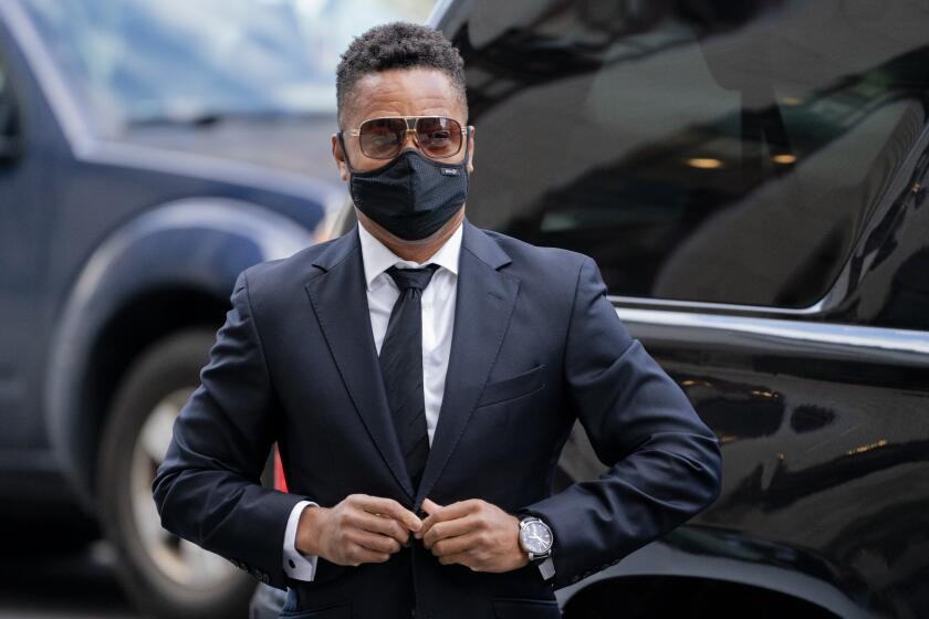 A man wearing sunglasses, a mask, dark suit and tie