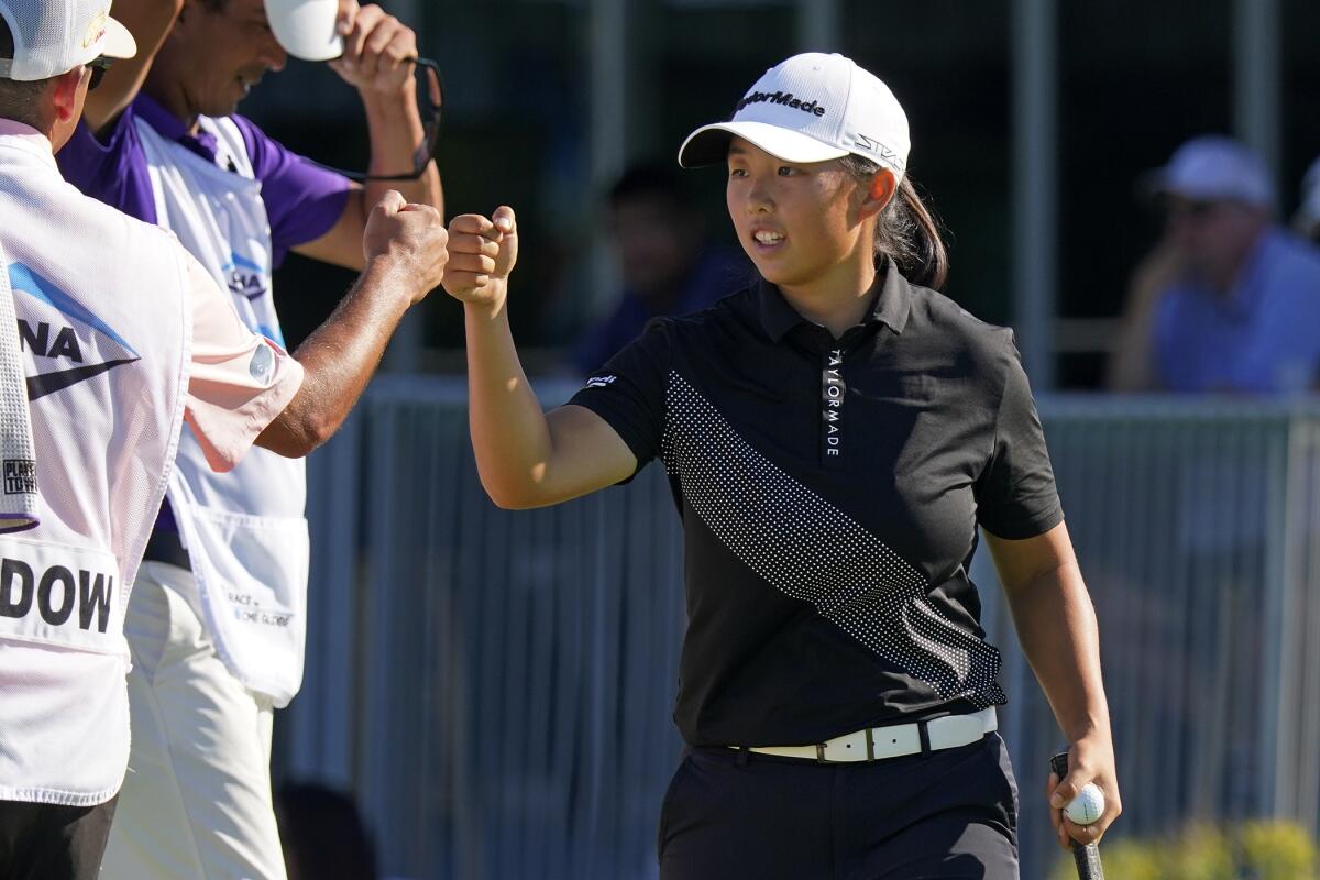 Ruoning Yin, of China, fist-bumpts a caddie after finishing the first round of the Dana Classic LPGA golf tournament Thursday, Sept. 1, 2022, at Highland Meadows Golf Club in Sylvania, Ohio. (AP Photo/Gene J. Puskar)