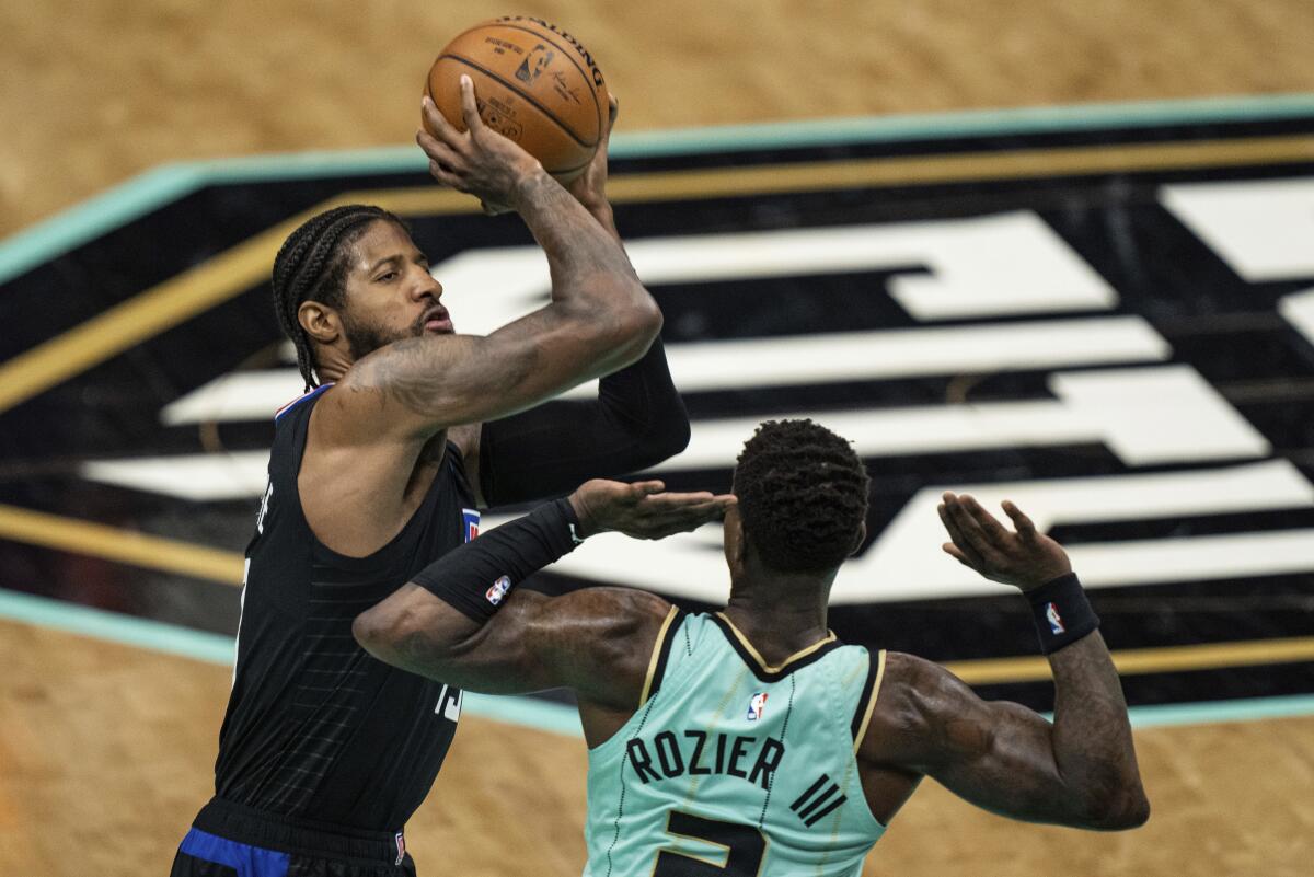 Los Angeles Clippers guard Paul George shoots the ball over Charlotte Hornets guard Terry Rozier during the first half of an NBA basketball game in Charlotte, N.C., Thursday, May 13, 2021. (AP Photo/Jacob Kupferman)