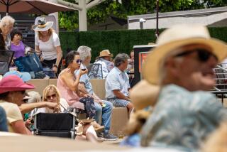 =A crowd listens to the Miskey Mountain Boys at the Festival of Arts in Laguna Beach.