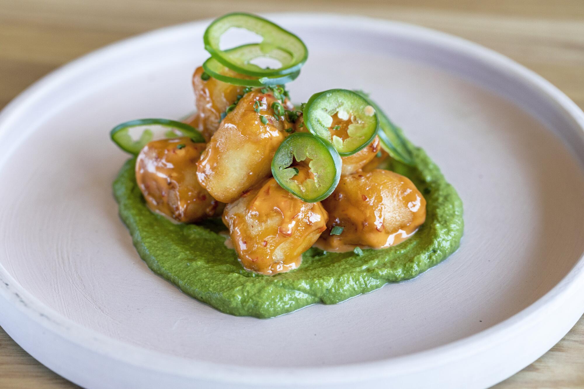 gnocchi plated over green sauce 