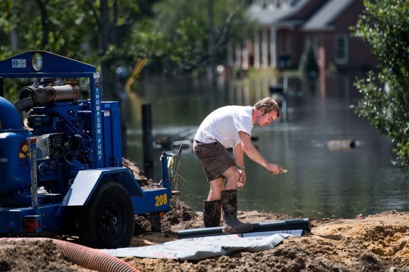 CONWAY, SC - SEPTEMBER 23: Archie Sanders cuts plastic sheeting while building a temporary levee to hold back floodwaters caused by Hurricane Florence near the Waccamaw River on September 23, 2018 in Conway, South Carolina. Floodwaters are expected to continue to rise in Conway over the next two days. (Photo by Sean Rayford/Getty Images) ** OUTS - ELSENT, FPG, CM - OUTS * NM, PH, VA if sourced by CT, LA or MoD **