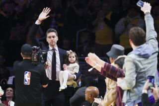 LOS ANGELES, CALIF. - MAR. 7, 2023. Former Los Angeles Lakers Pau Gasol waves to the fans while holding onto his daughter Elisabet Gianna Gasol as he makes his way on the court during the game against the Memphis Grizzlies in an NBA game at Crypto.com Arena in Los Angeles on Tuesday, Mar. 7, 2023. (Luis Sinco / Los Angeles Times)