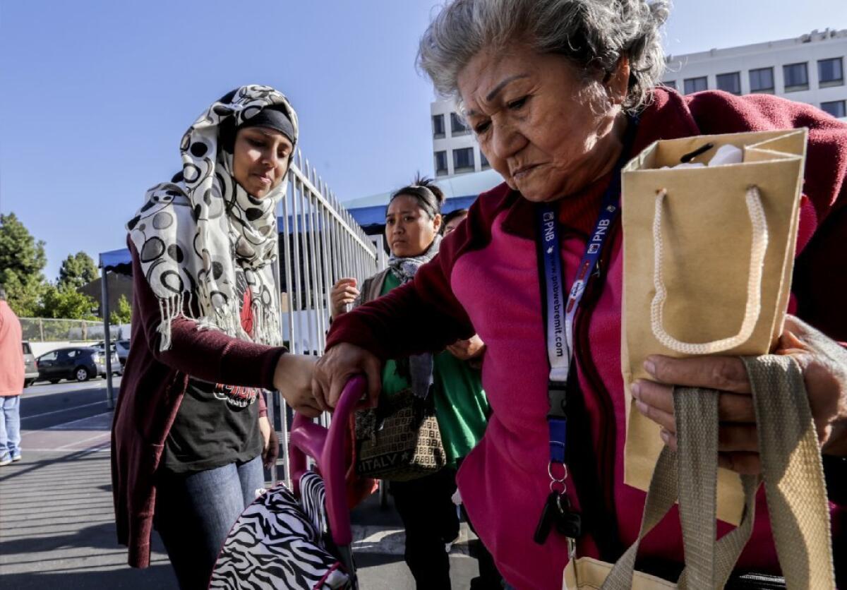 Nishat Brinta, left, distributes Christmas gifts at a weekly food bank set up by the Islamic Center of Southern California in Los Angeles.