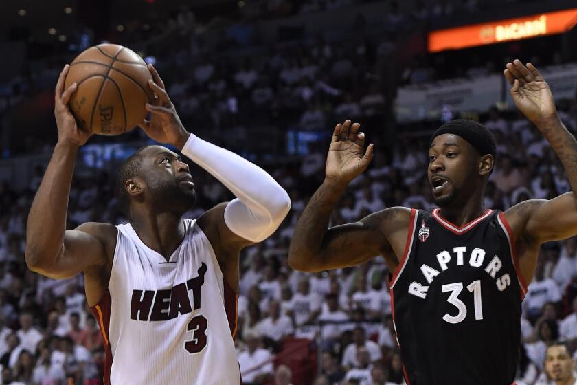 Miami's Dwyane Wade is defended by Toronto's Terrance Ross.