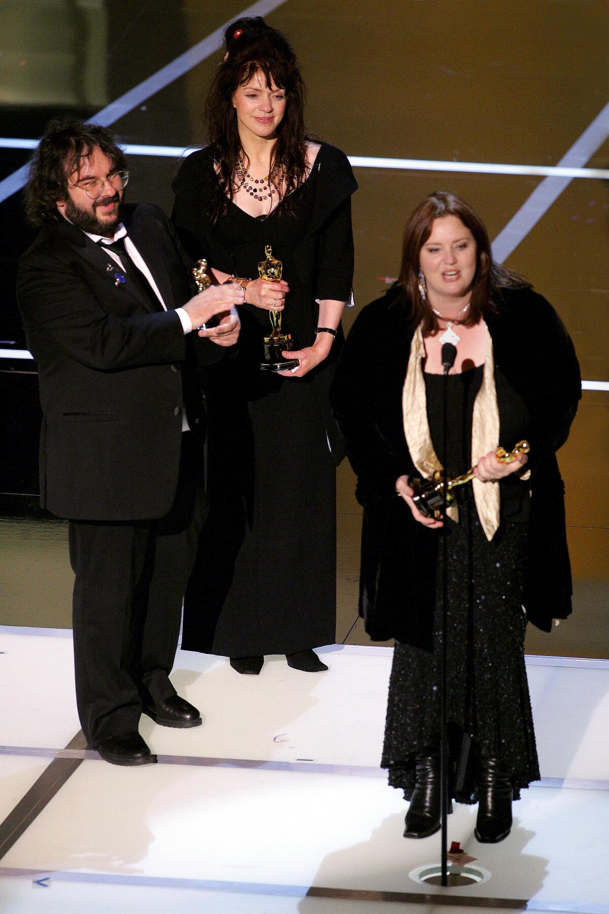 Peter Jackson, Fran Walsh and Philippa Boyens accept their shared adapted screenplay award at the 2004 Oscars.