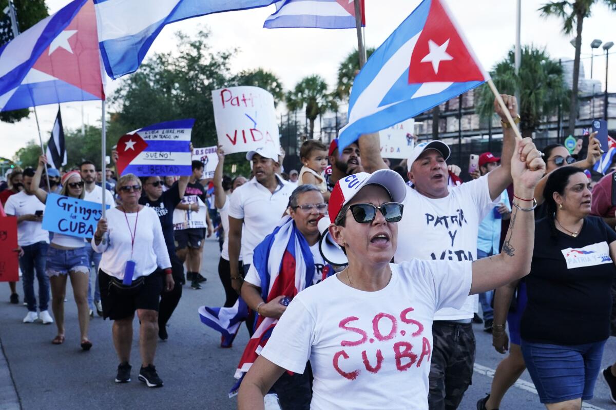 Manifestantes llevan banderas cubanas y gritan lemas de solidaridad con el pueblo cubano 