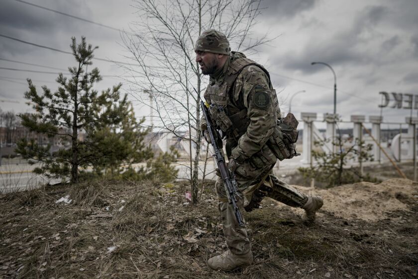 A Ukrainian serviceman takes a shooting position as he looks at approaching vehicles in Irpin, on the outskirts of Kyiv, Ukraine, Wednesday, March 9, 2022. A Russian airstrike devastated a maternity hospital Wednesday in the besieged port city of Mariupol amid growing warnings from the West that Moscow's invasion is about to take a more brutal and indiscriminate turn. (AP Photo/Vadim Ghirda)
