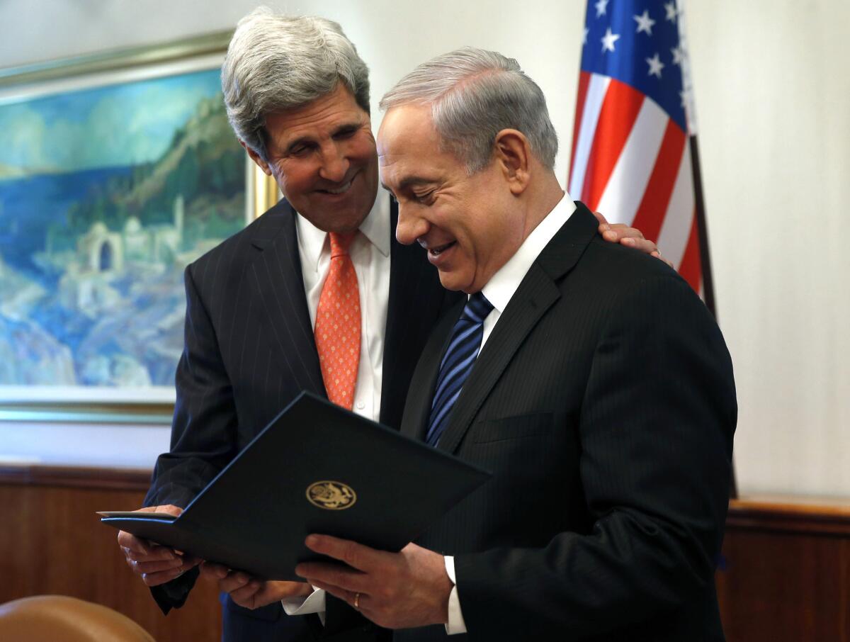 U.S. Secretary of State John F. Kerry, left, presents a gift to Israeli Prime Minster Benjamin Netanyahu in Jerusalem.