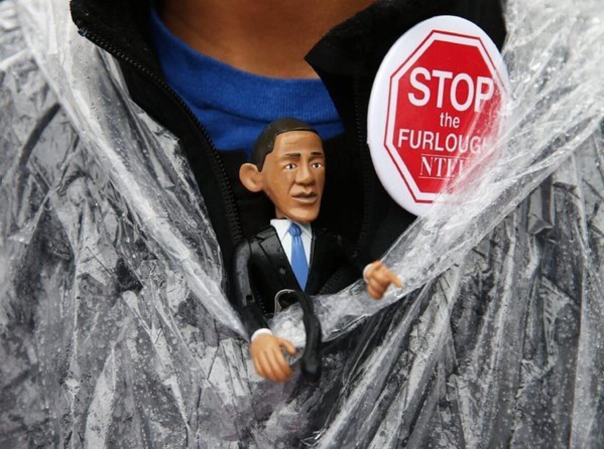 A protester wears an Obama figure during a rally outside the U.S. Capitol in Washington to urge an end to the government shutdown.