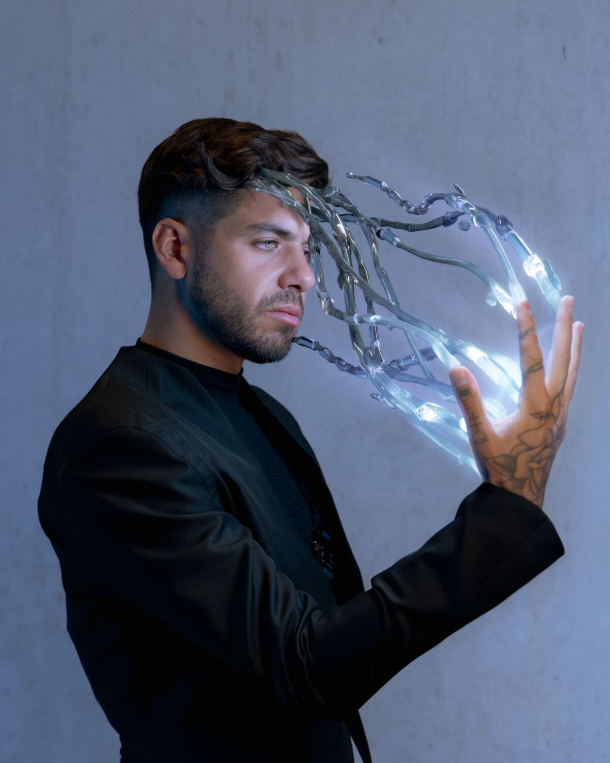 A musician with beams of light and robot fingers emerging from his hand. 