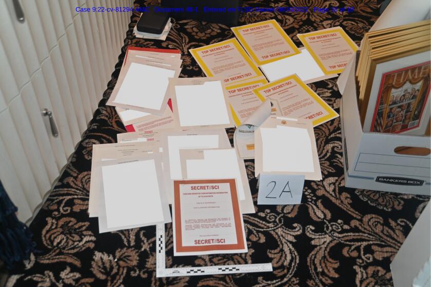A photo of classified documents seized during a search of Mar-a-Lago strews about on the floor