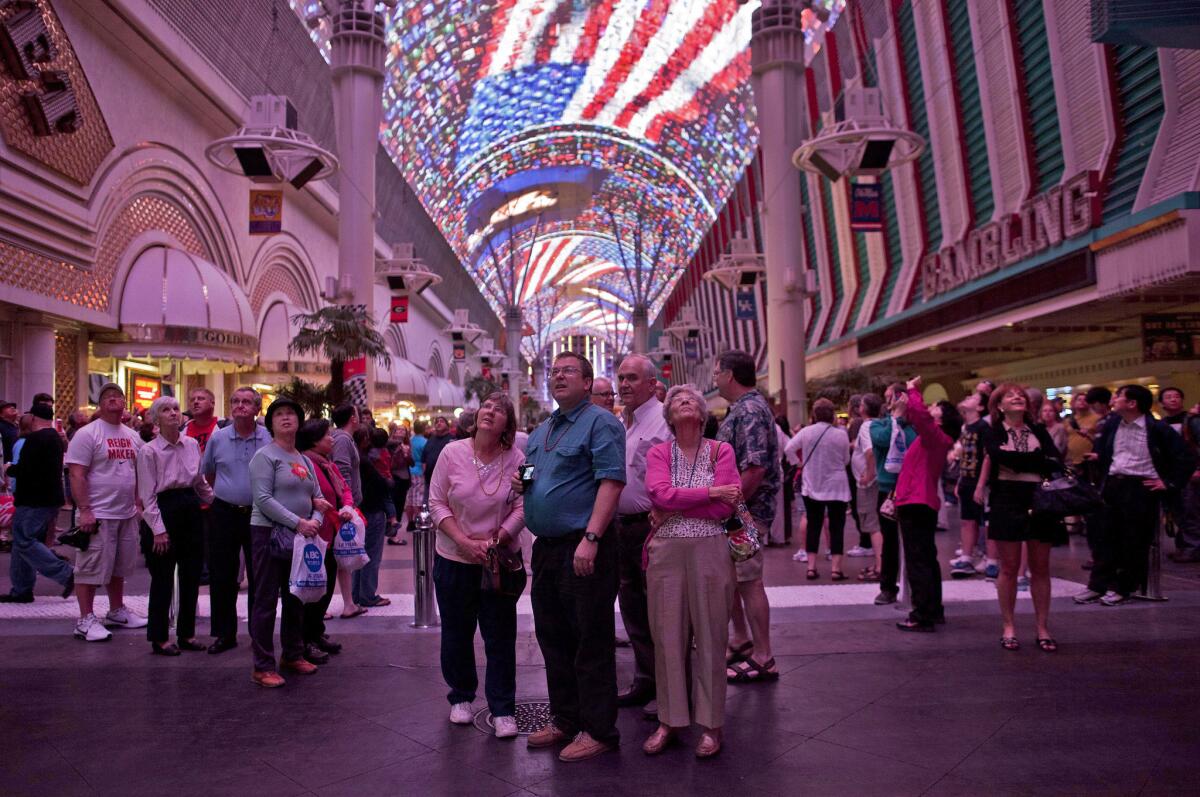 Tourists watch the canopy light show at the Fremont Street Experience in Las Vegas. The video canopy will feature a tribute to pop artist Prince tonight.