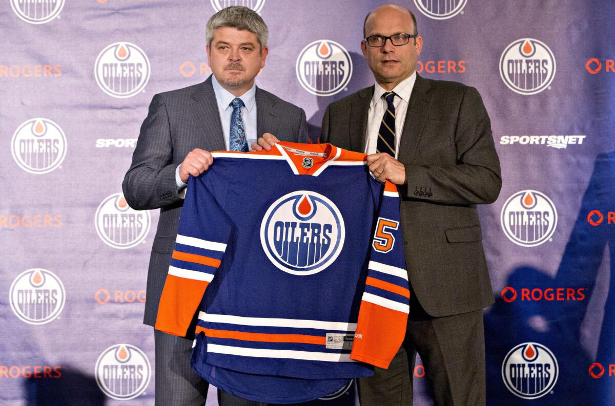 Todd McLellan, left, and Peter Chiarelli, President of Hockey Operations and General Manager of the Edmonton Oilers, hold up a jersey during a news conference after the Oilers announced McLellan as their new head coach.