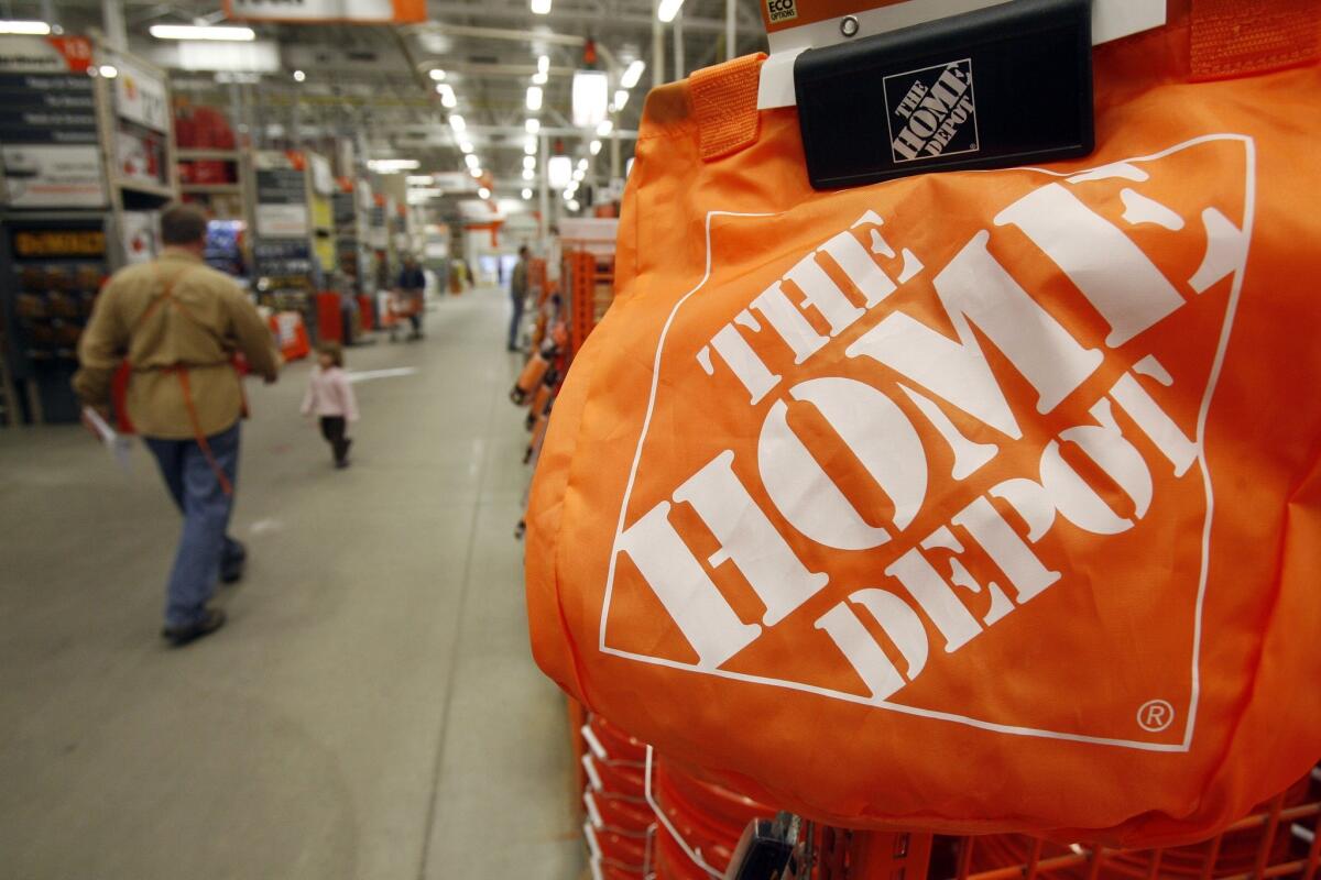 Shoppers and store employees walk through the aisles at the Home Depot store in Williston, Vt.