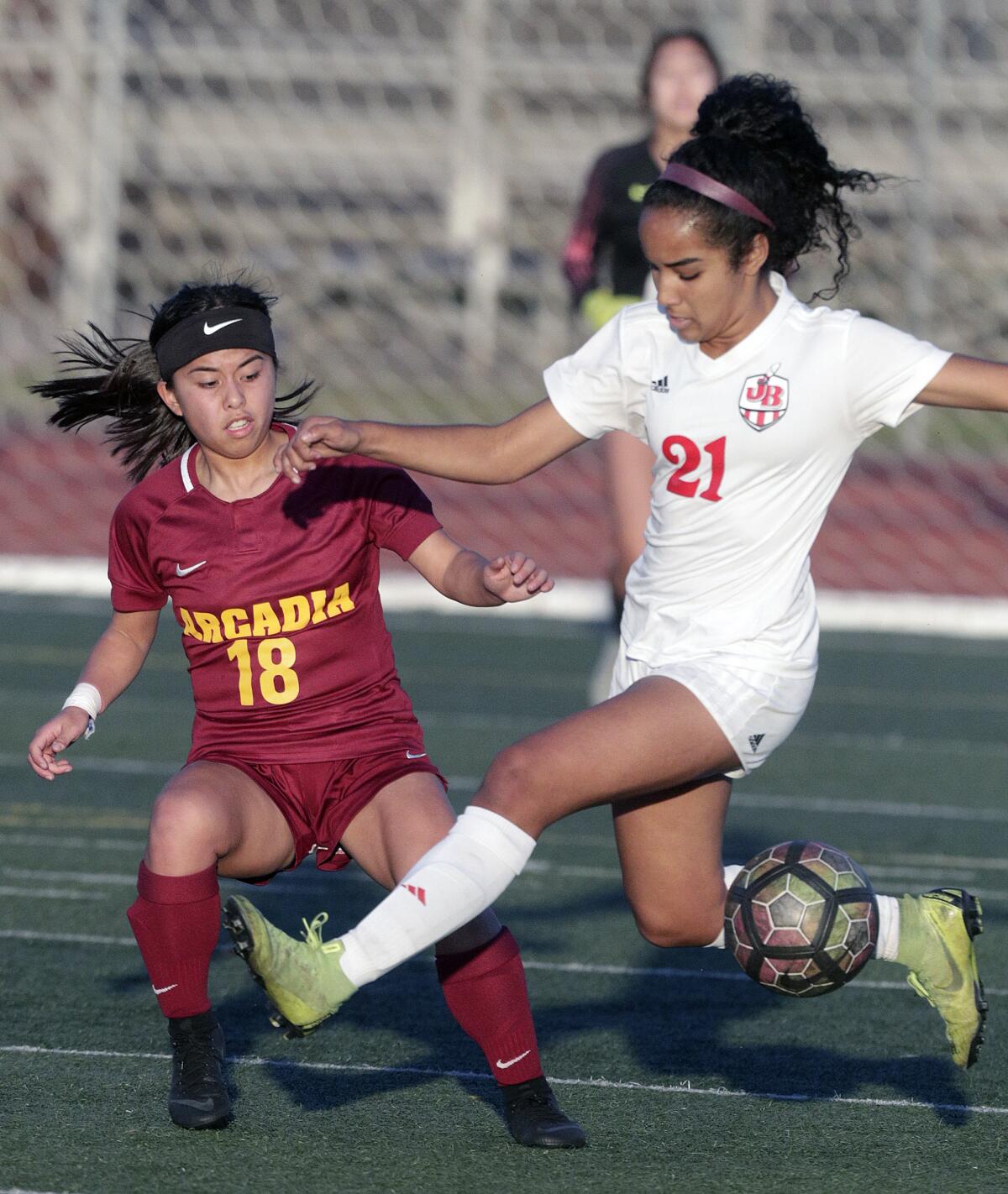 Arcadia's Kayla Noda just clears the ball before Burroughs' Lauryn Bailey reaches her in a Pacific League girls' soccer game at Arcadia High School in Arcadia on Tuesday, January 28, 2020.