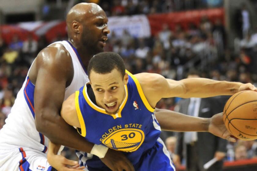 Lamar Odom, left, defends Golden State's Stephen Curry, who scored 23 points in the Warriors' 114-110 victory over the Clippers at Staples Center on Saturday night.