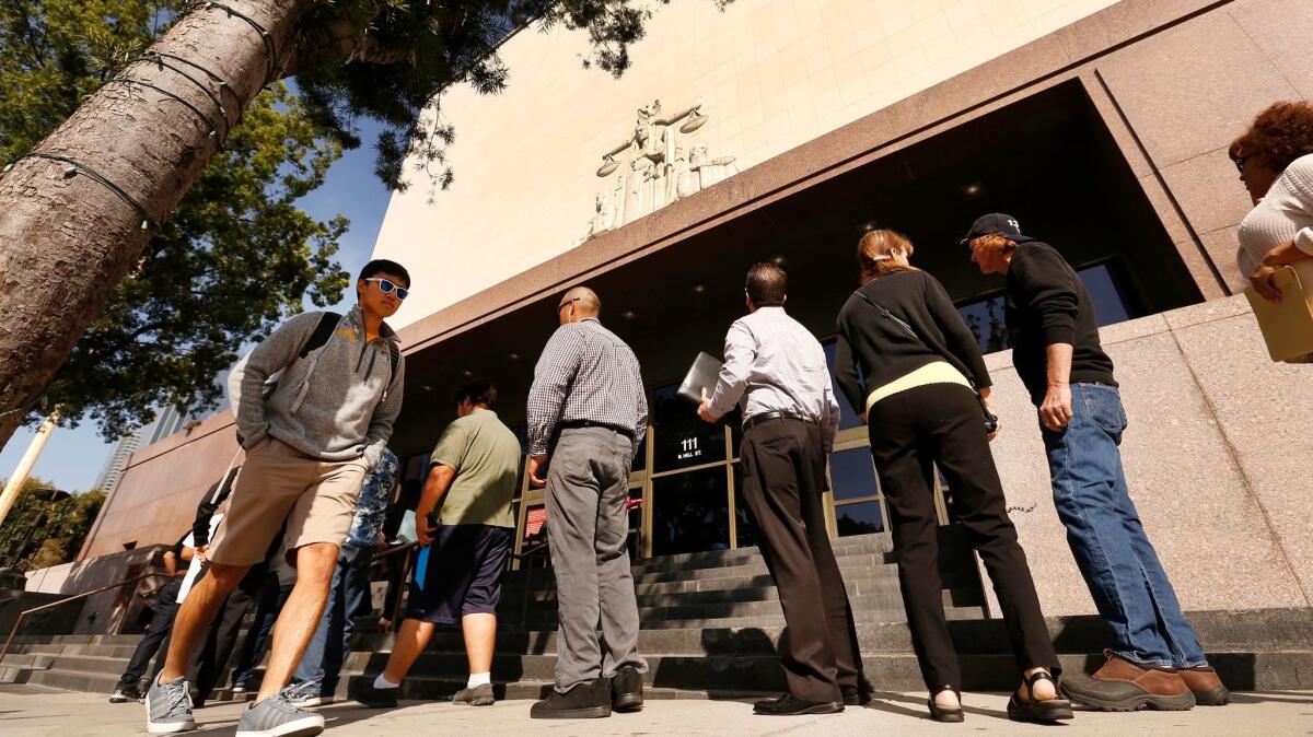 A line of people wait to enter the Stanley Mosk Courthouse, which is the main civil courthouse of the Superior Court of Los Angeles County in downtown Los Angeles.