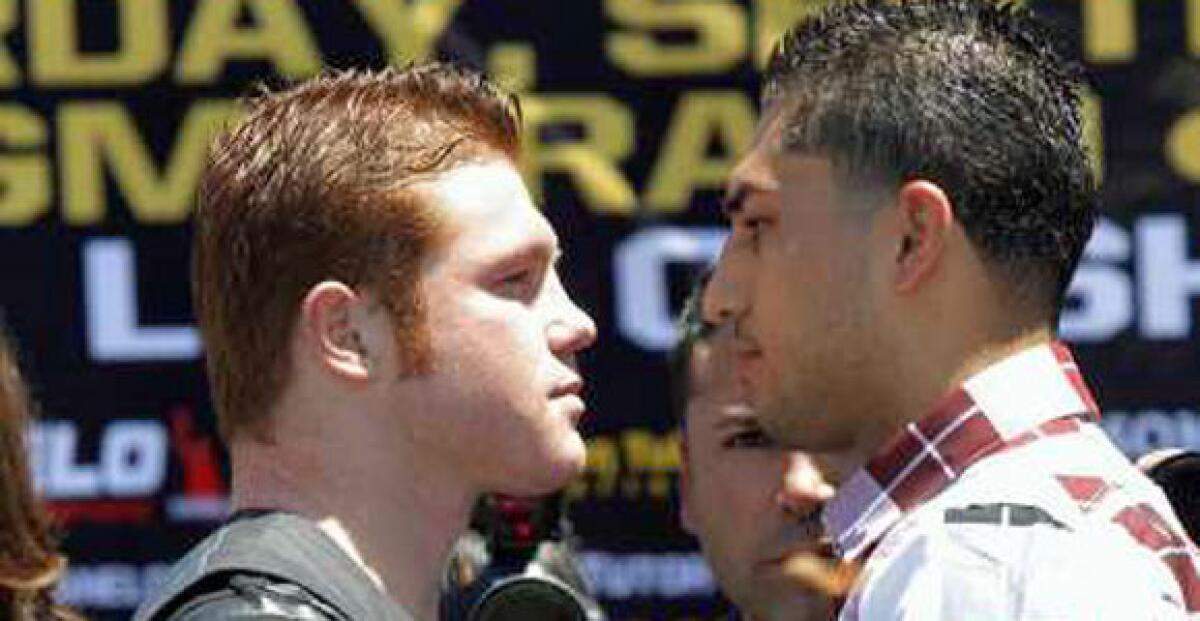 Saul "Canelo" Alvarez, left, and Josesito Lopez face off as they pose for photos during a news conference Tuesday.