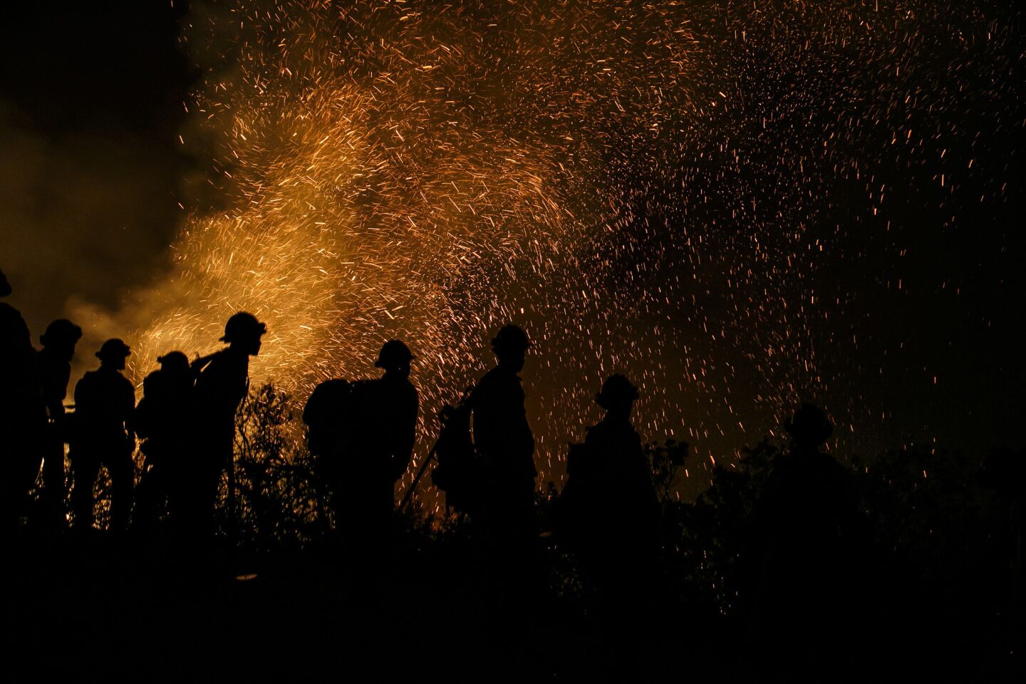 Firefighter monitors the embers in the air as they conduct a burn-out operation in El Capitan Canyon in Goleta.
