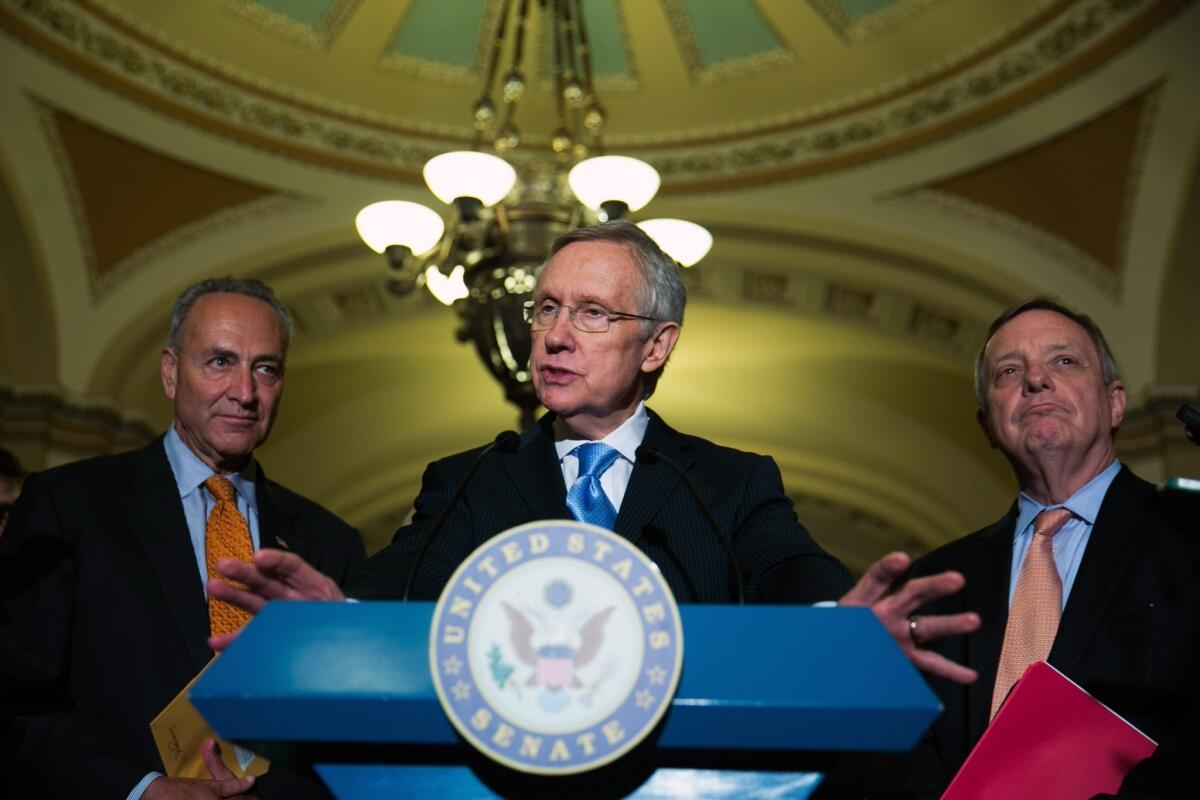 Sen. Chuck Schumer (D-N.Y.), from left, Senate Majority Leader Harry Reid (D-Nev.) and Sen. Dick Durbin (D-Ill.) speak to the media after Senate leaders reached a deal to avert a move by Reid to end Senate filibusters on presidential nominees for executive branch posts.