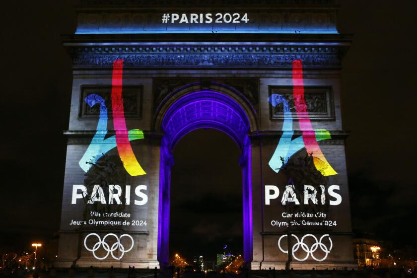 The Eiffel Tower-shaped bid logo for Paris 2024 is unveiled on the Arc de Triomphe on the Champs Elysees on Feb. 9.